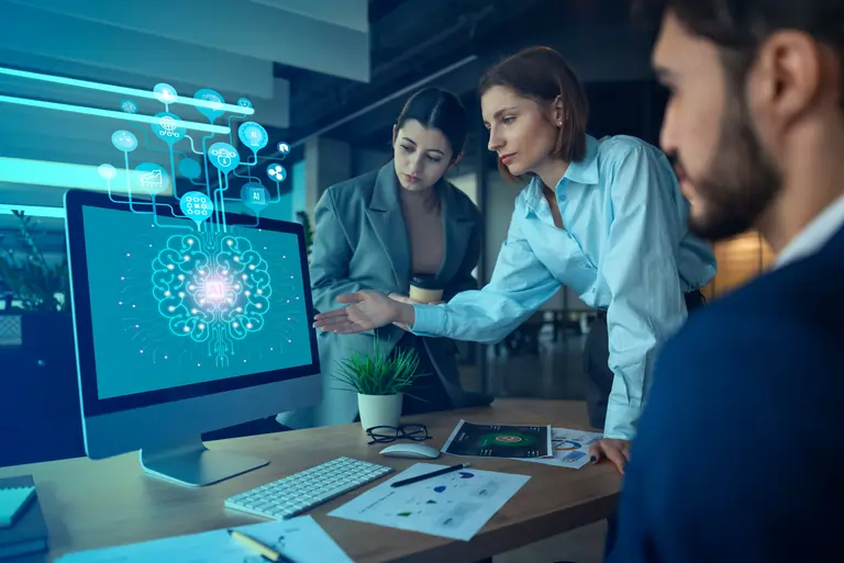 Group of people working with AI tools and looking at a monitor